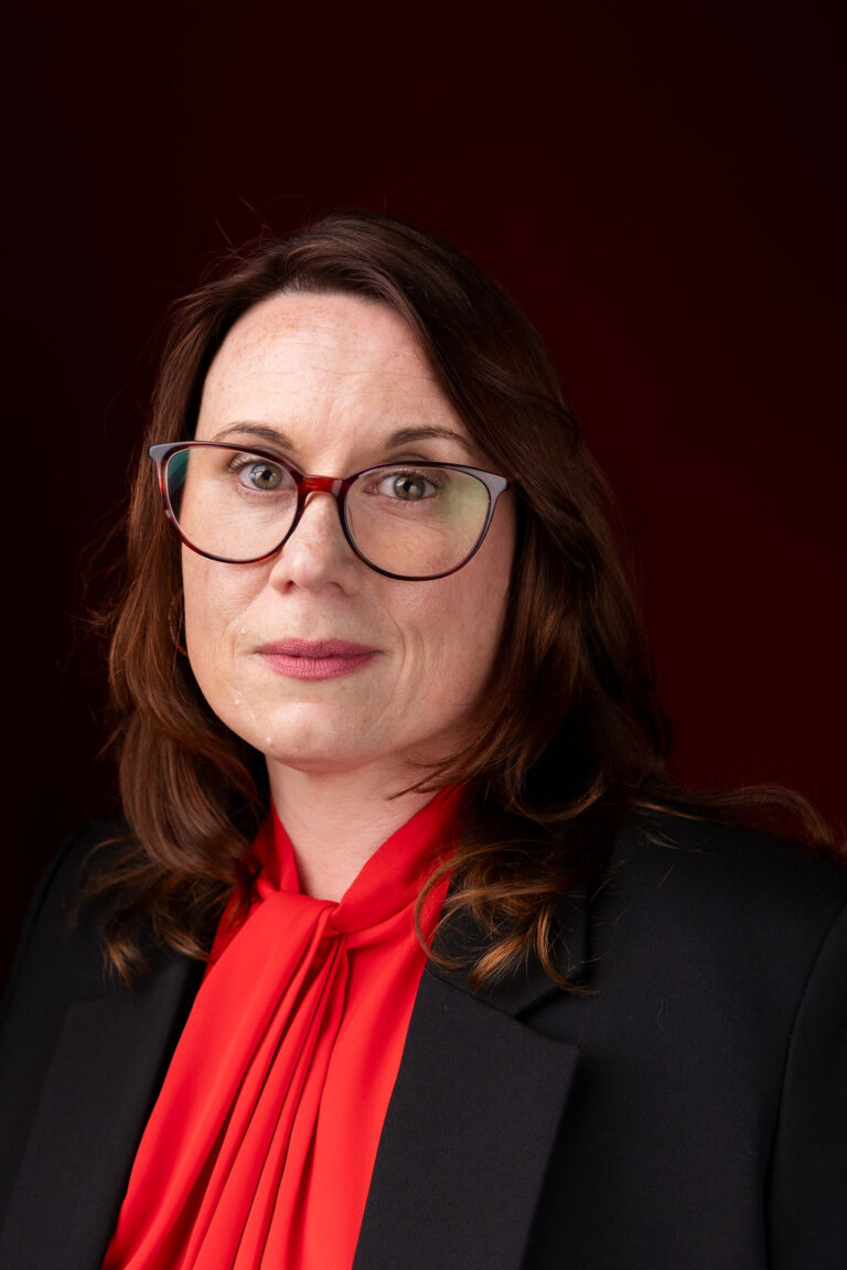 Woman in a red top and dark jacket